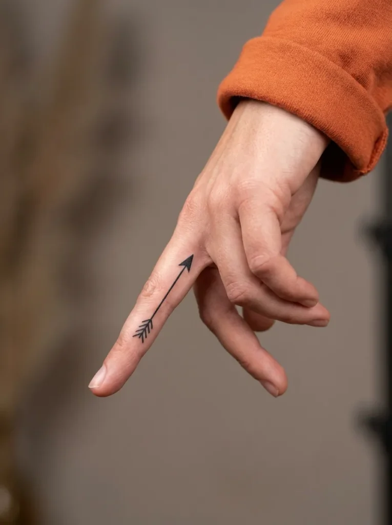 Small Arrow Inner Finger Tattoo