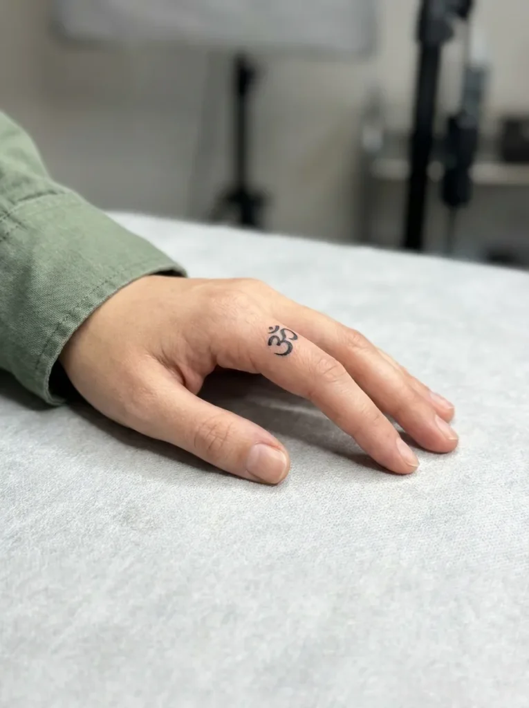 Small Symbol Inner Finger Tattoo