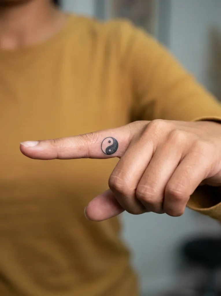 Small Yin Yang Inner Finger Tattoo