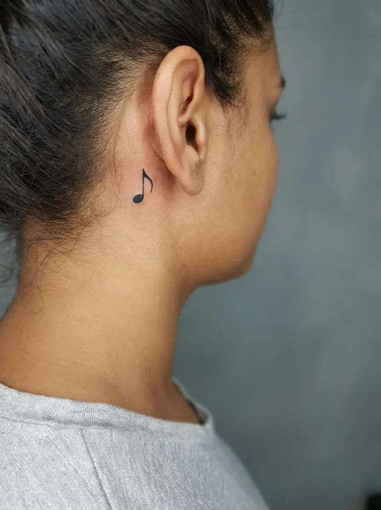 Tiny Music Note Behind Ear Tattoo